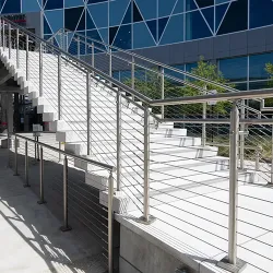 Stainless Steel Cable Railings on each side of concrete steps leading up to an entrance